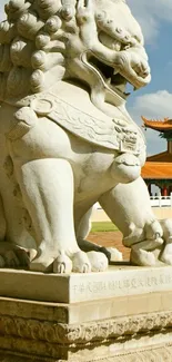 Stone lion statue at Asian temple with blue sky.