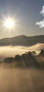 Sunrise over misty mountains with clouds and sunlight rays.