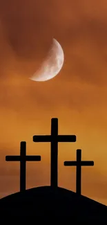 Three silhouetted crosses against a vibrant orange sunset with a crescent moon.