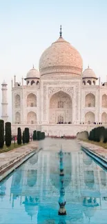 Taj Mahal reflected in serene water under a blue sky.