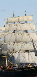 Majestic tall ship sailing on a calm ocean under a clear blue sky.