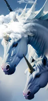 Majestic unicorns with horns and wings against a sky background wallpaper.