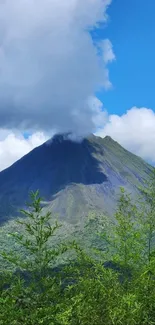 Volcanic mountain under blue sky with lush greenery.