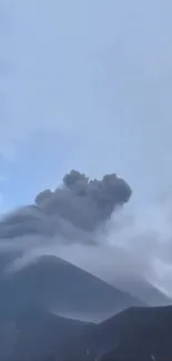 Stunning view of a volcano erupting with smoke against a blue sky.