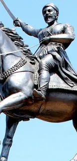 Warrior statue on horseback against blue sky.