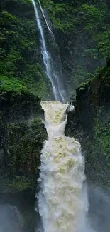 Majestic waterfall cascading through lush green canyon landscape.