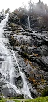 Stunning mobile wallpaper of a cascading waterfall on rocky cliffs.