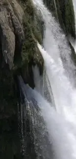 Majestic waterfall with lush greenery and misty water.