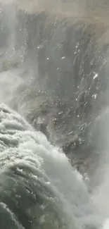 Majestic waterfall cascading over rocky cliffs with mist.