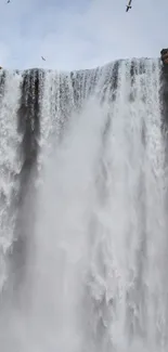 Majestic waterfall cascading down rocky cliffs, creating a serene scene.