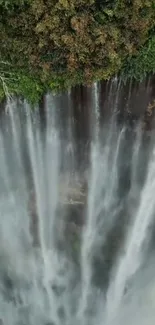 Majestic waterfall cascading with lush greenery background.