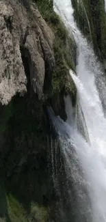 Majestic waterfall cascading down rocky cliffs in nature wallpaper.