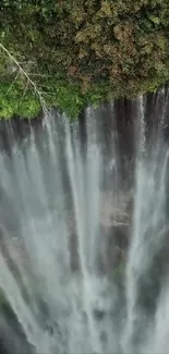 A breathtaking aerial view of a waterfall cascading amid vibrant greenery.