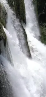 Majestic waterfall with cascading white water over green rocks.