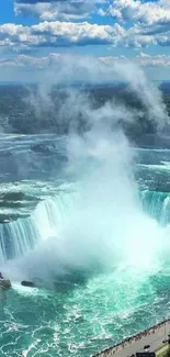 Majestic waterfall with blue sky and clouds in a serene natural setting.