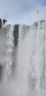 Majestic waterfall cascading down rocks, creating a serene natural scene.