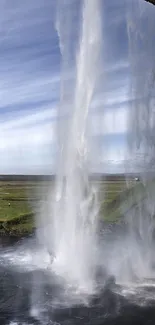 Majestic waterfall cascading over lush green landscape.