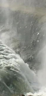 Majestic waterfall cascading down rocks with mist.