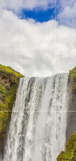 Waterfall cascading between green cliffs under a blue sky.