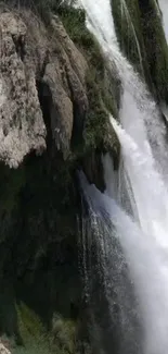 Majestic waterfall with rocky cliffs and vibrant greenery.