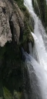 Majestic waterfall cascading over rocks in a serene natural setting.