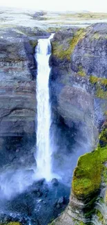 Stunning waterfall with vibrant cliffs and greenery, set against a serene landscape.