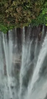 Majestic waterfall with lush green foliage cascading down.