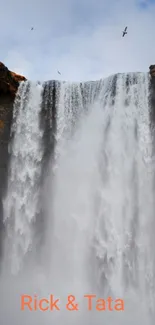 Majestic waterfall cascading amid rocky cliffs with a serene atmosphere.