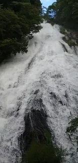 Cascading waterfall with lush green surroundings.