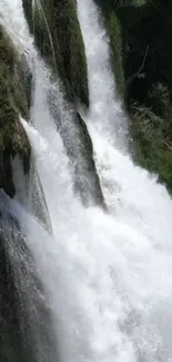 Serene waterfall cascading over rocks with lush greenery.