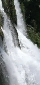 Majestic waterfall with lush greenery and rushing water.