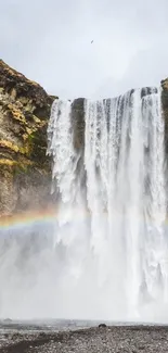 Majestic waterfall with a rainbow in scenic nature view.