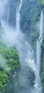 Majestic waterfalls cascading through lush greenery enveloped in mist.