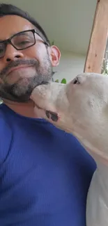 Man smiling with dog on a sunny porch scene.