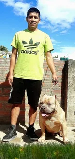 Man holding a dog outside on a sunny day.