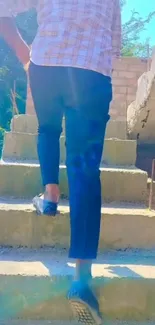 Man climbing sunlit stairs with blue hues.