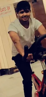 Man cycling indoors at a gym setting.