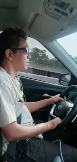 A man is driving a modern car on a highway.