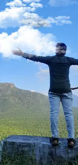 Hiker with arms open enjoying stunning mountain landscape.