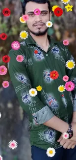 Man in a green shirt stands with leafy backdrop.