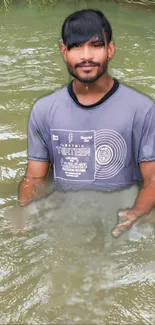 Man wearing grey shirt standing in river water, providing a natural serene backdrop.