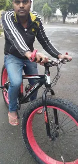 Man riding a black fat tire bike on a road.