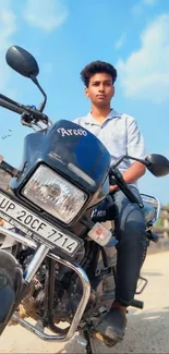 Young man riding a motorcycle under a bright blue sky.