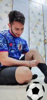 Man tying shoelaces in a blue sports jersey with geometric background.