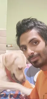 Young man smiling with a Labrador dog in a cozy home setting.