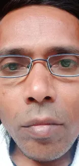 Closeup portrait of a man wearing glasses with a neutral expression.