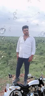 A man standing in nature with a motorcycle and raindrop effects.