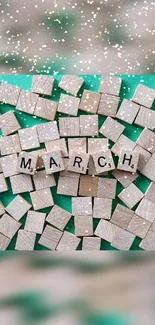 March wooden letter tiles on green background.