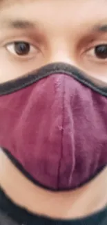 Masked person in a maroon mask close-up, ideal for mobile wallpaper.