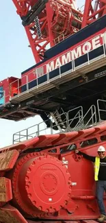 Massive red construction crane close-up with worker.